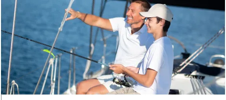 Father and son fishing from a yacht